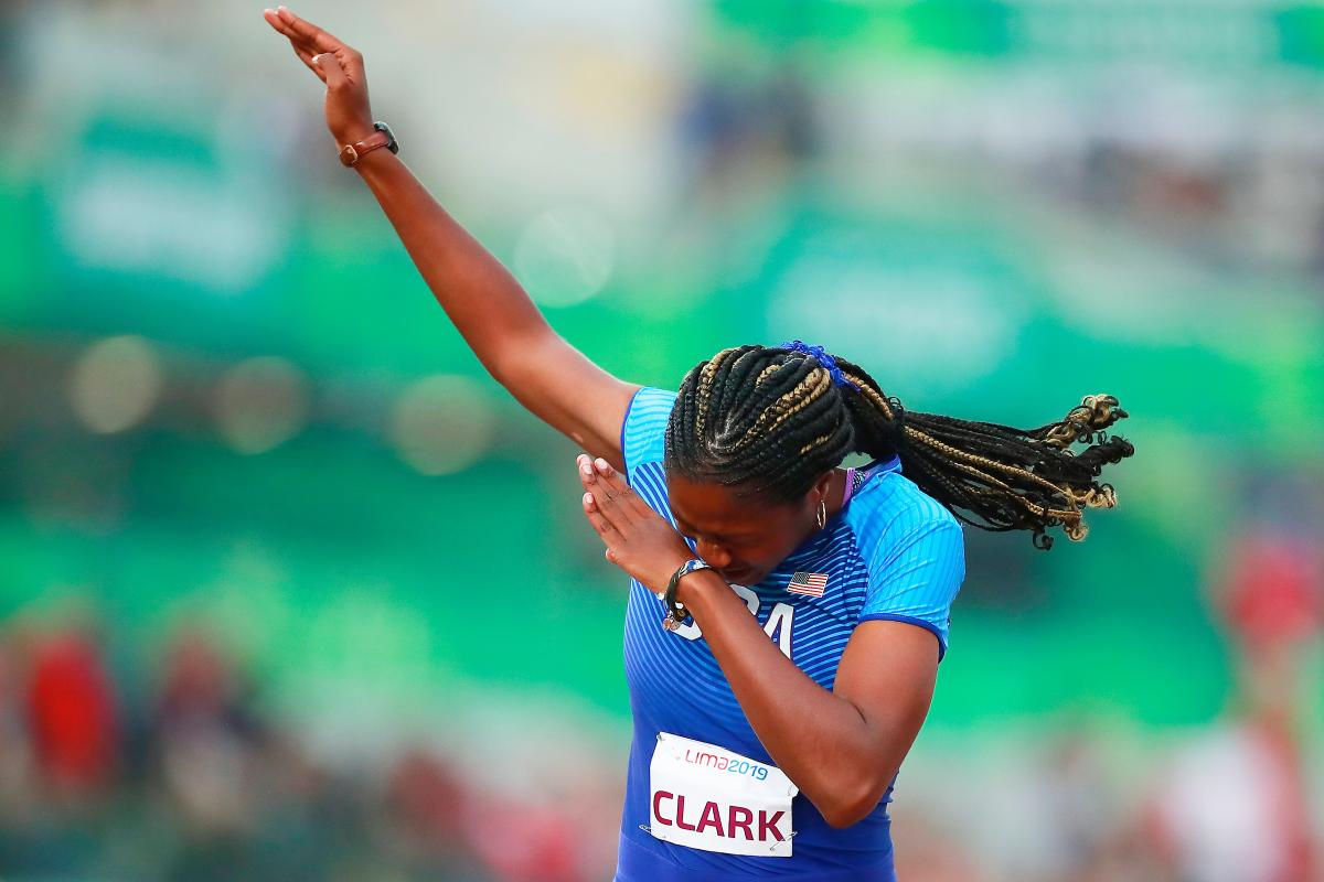 a female Para athlete celebrates on the finish line