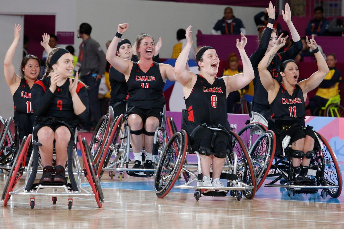 a group of female wheelchair basketball players cheering