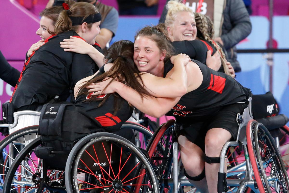a group of female wheelchair basketball players hugging