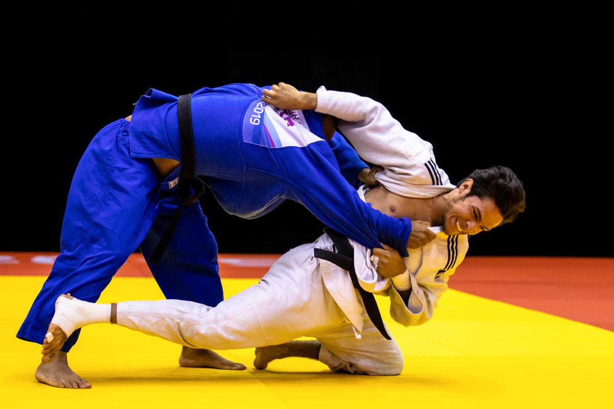 two male judokas fighting on the mate
