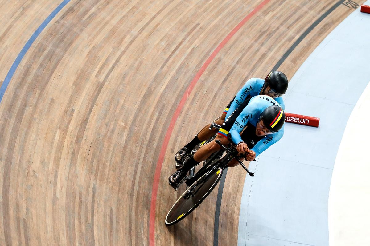 a male Para cycling tandem goes round a corner on the track