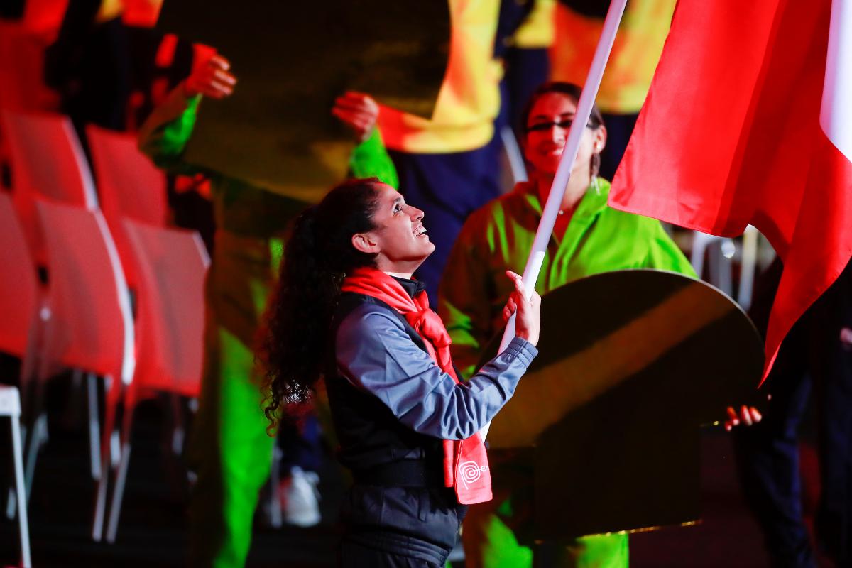 a female athlete carries a flag