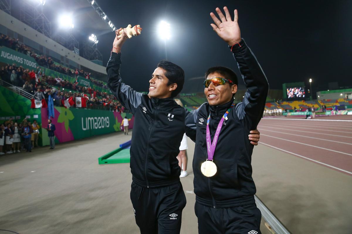 two men wave to the crowd