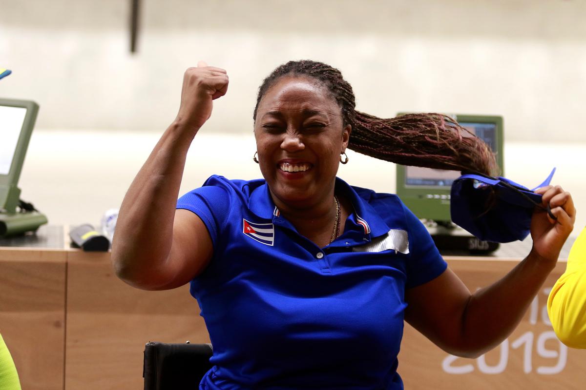 a female Para shooter clenches her fist in celebration