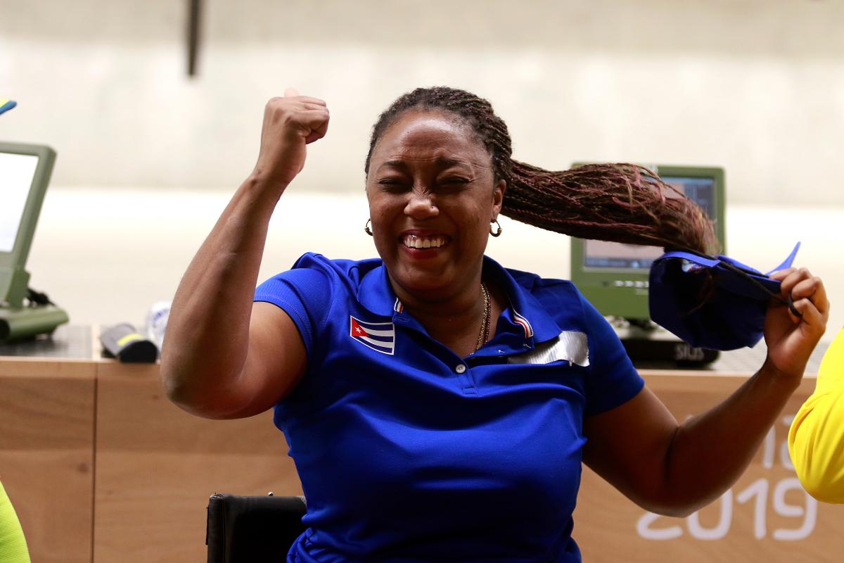 a female Para shooter clenches her fist in celebration