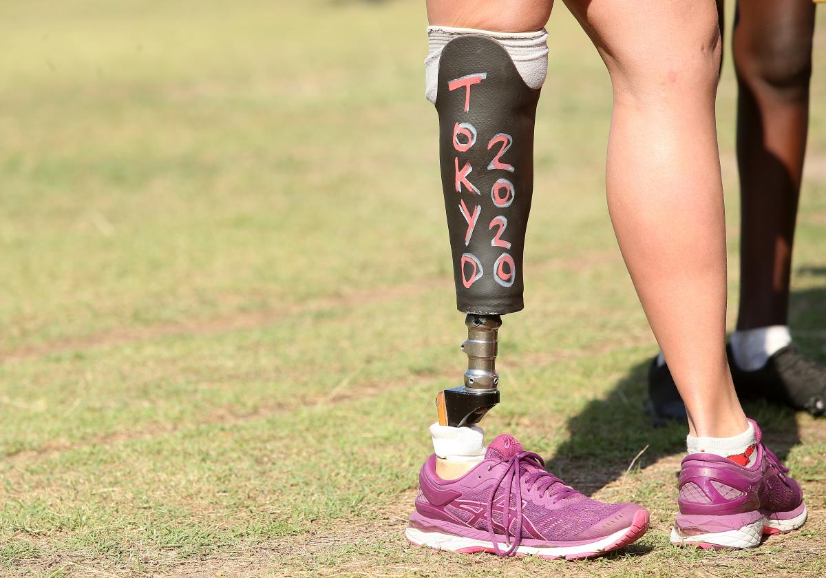 a woman standing with a prosthetic leg that has Tokyo 2020 written on it