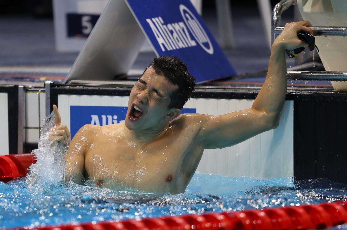 a male Para swimmer celebrates in the water