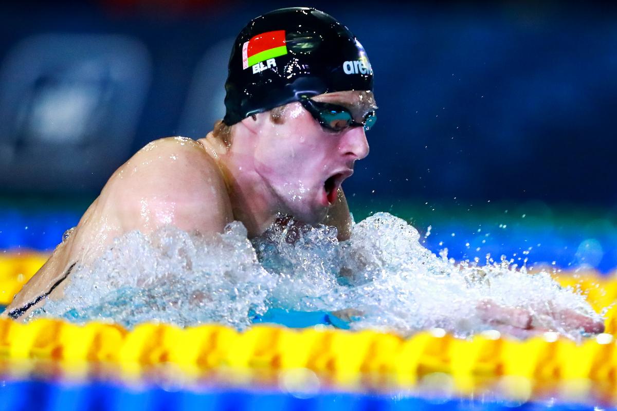 a male Para swimmer takes a breath during a breaststroke