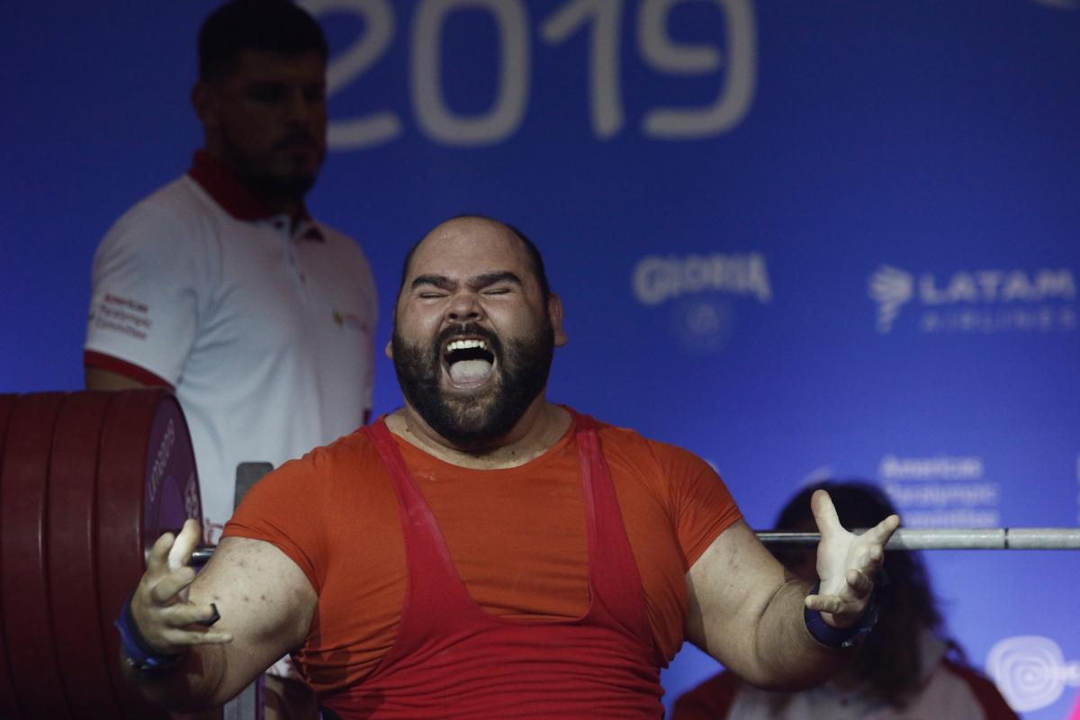 a male powerlifter celebrates on the bench