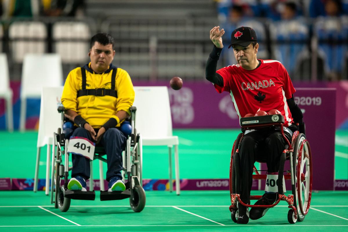 two male boccia players throwing a ball