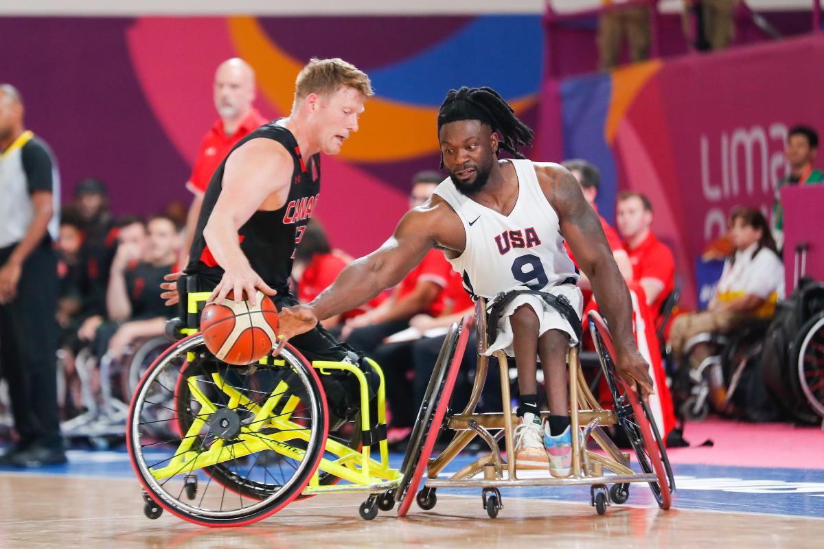 two male wheelchair basketball players fight for the ball