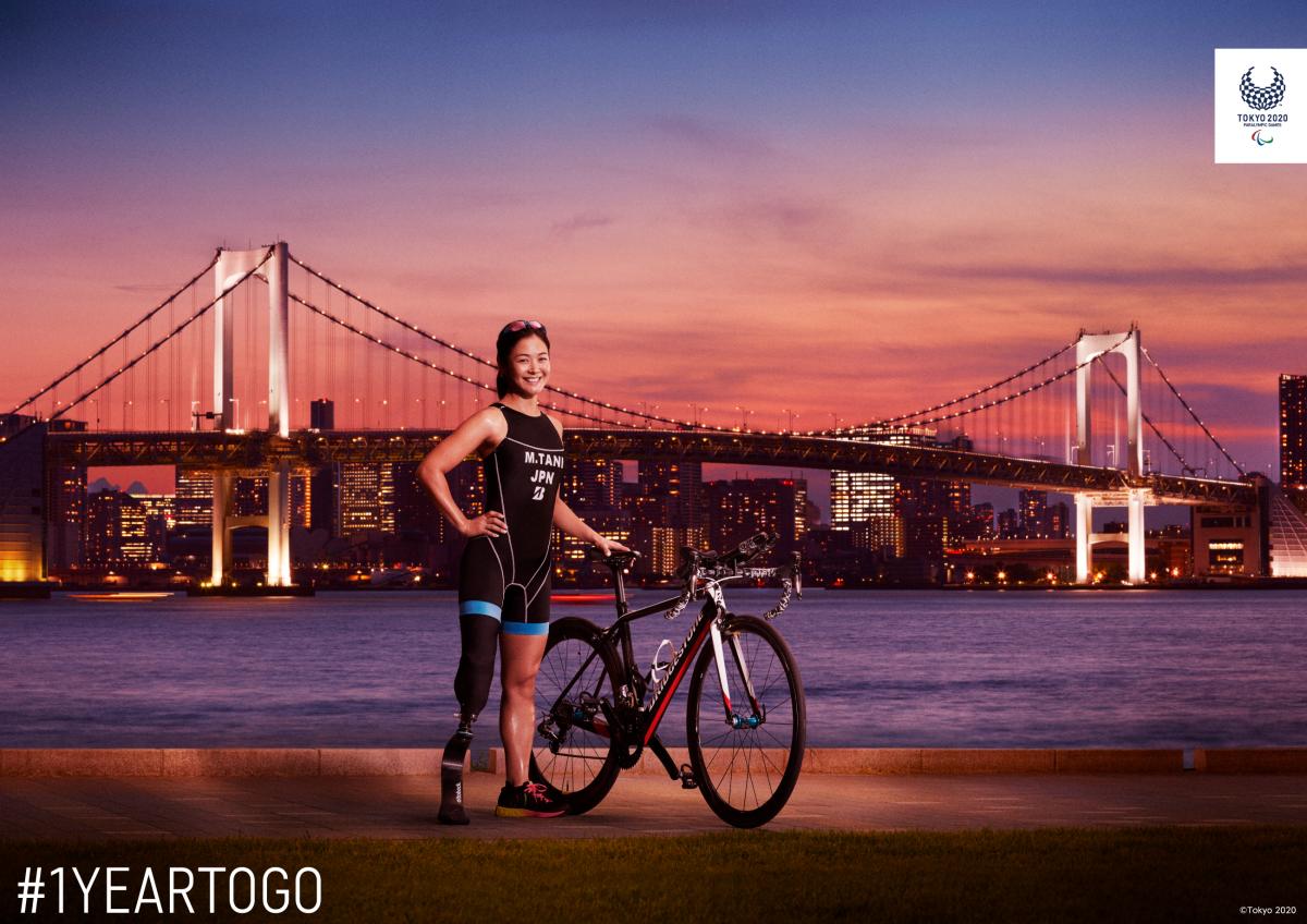 Japanese female triathlete poses with bridge in backdrop