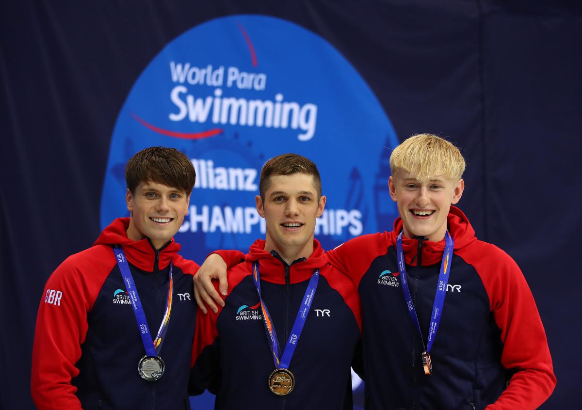 three male Para swimmers on the podium