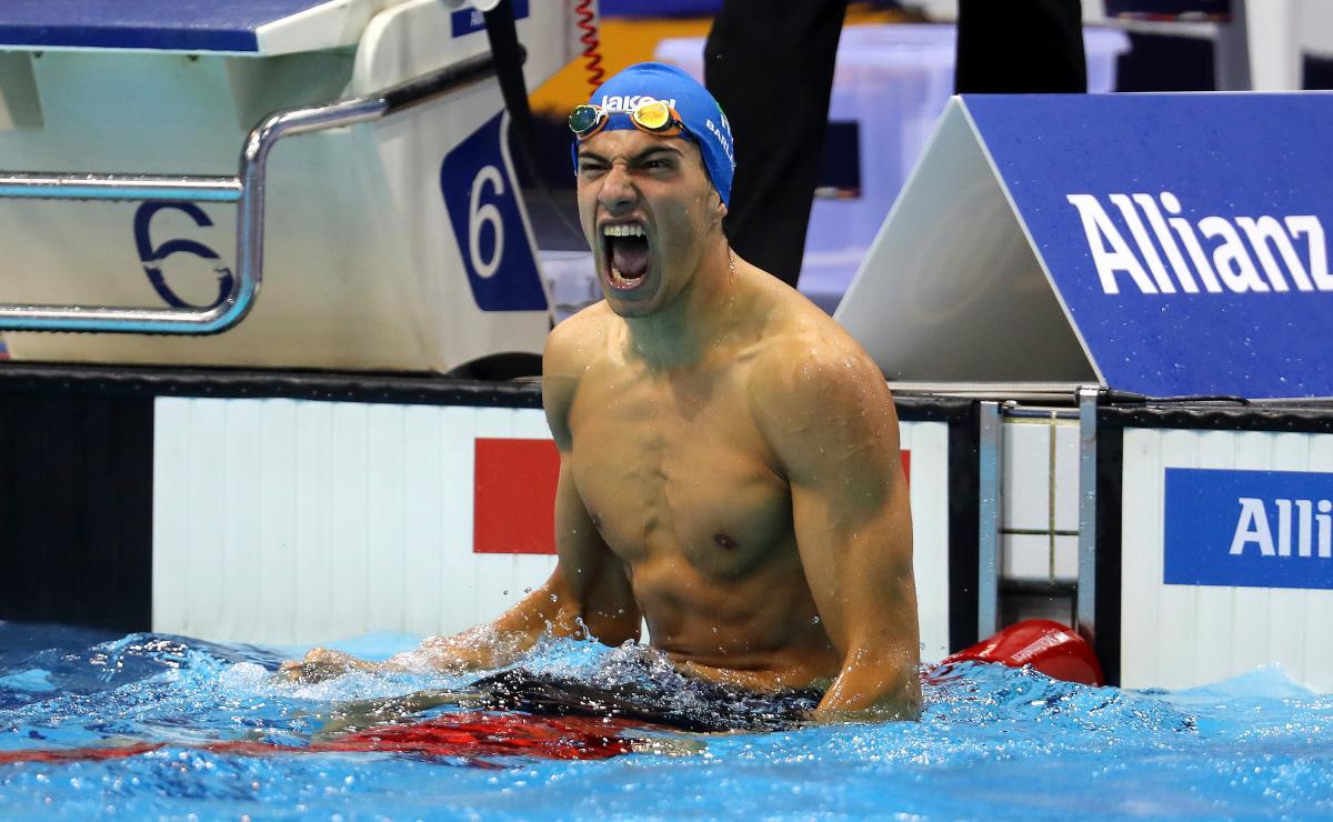 a male Para swimmer celebrates in the water