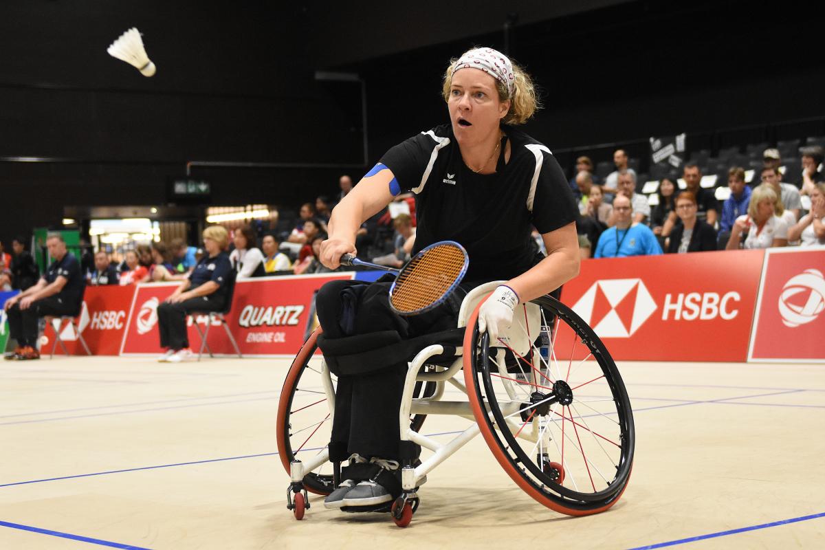 A woman in a wheelchair playing badminton 