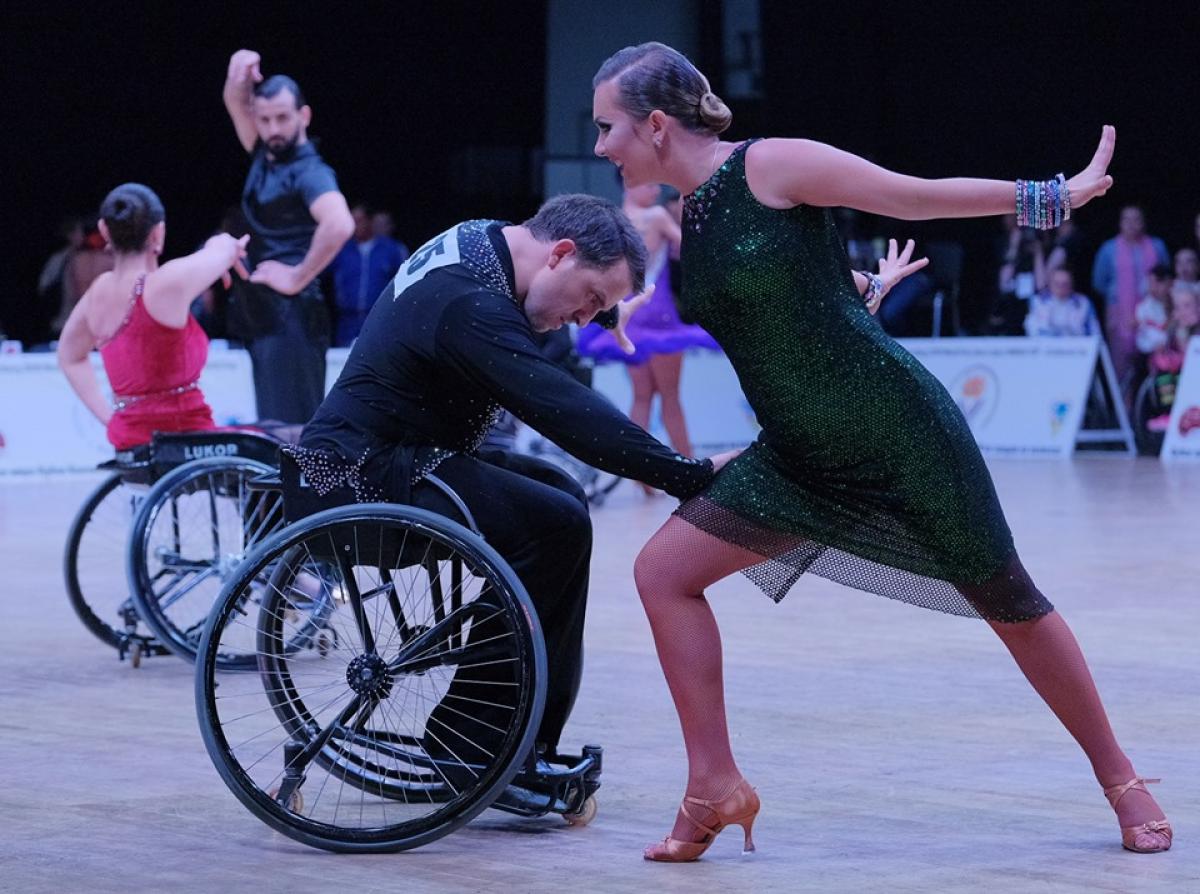 Man in wheelchair dancing with standing partner