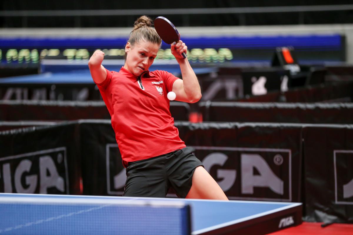 Woman with right arm impairment hits return shot in table tennis