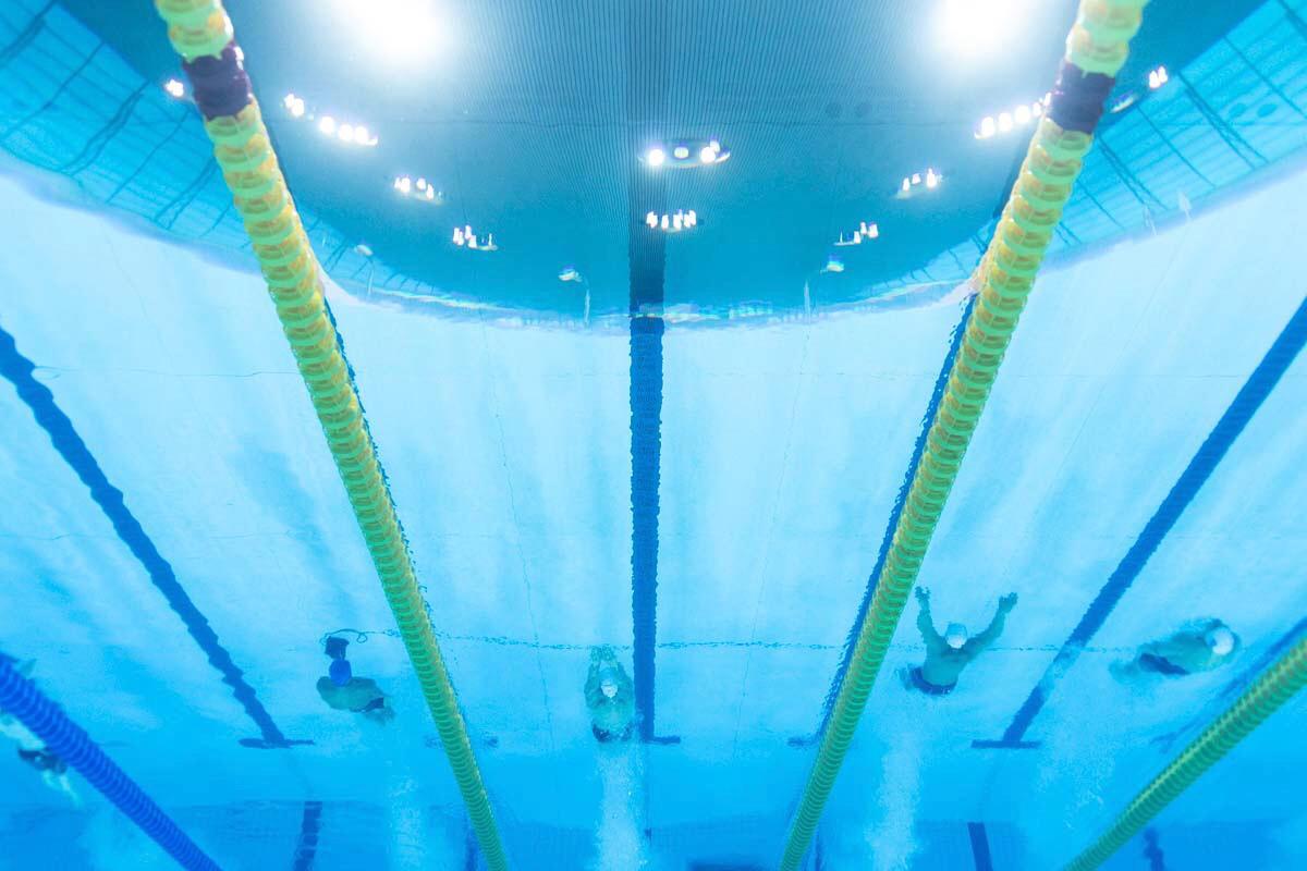 An underwater image of four men swimming in a pool