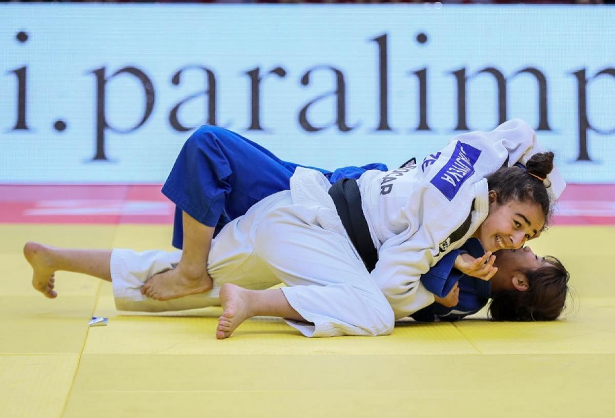 Azerbaijani judoka Shahana Hajiyeva holds her rival on the floor and smiles as she beats her