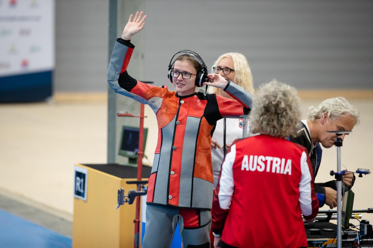 Female vision impaired shooter waves at audience