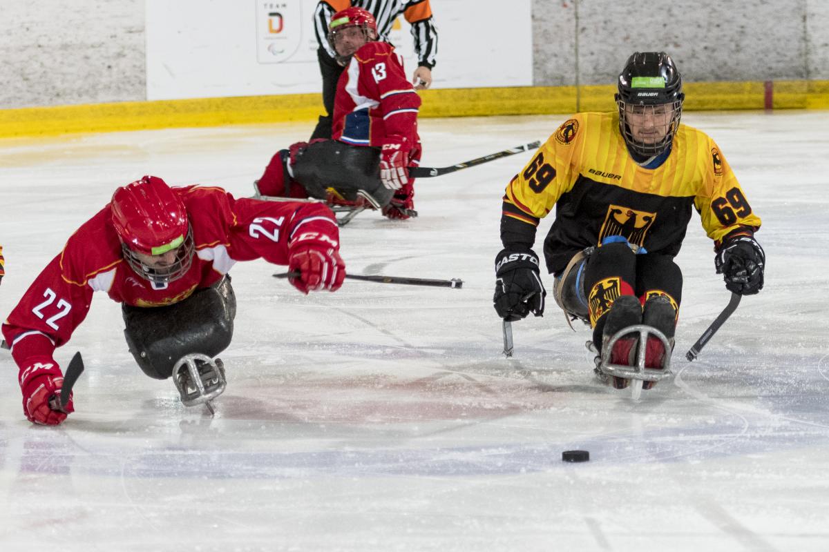 Two ice hockey players go for the puck