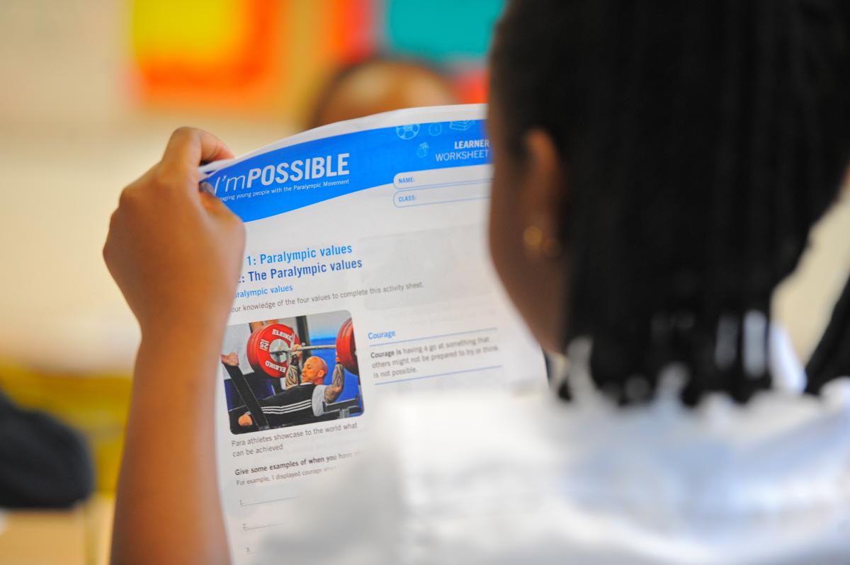 Girls read I'mPOSSIBLE education programme materials