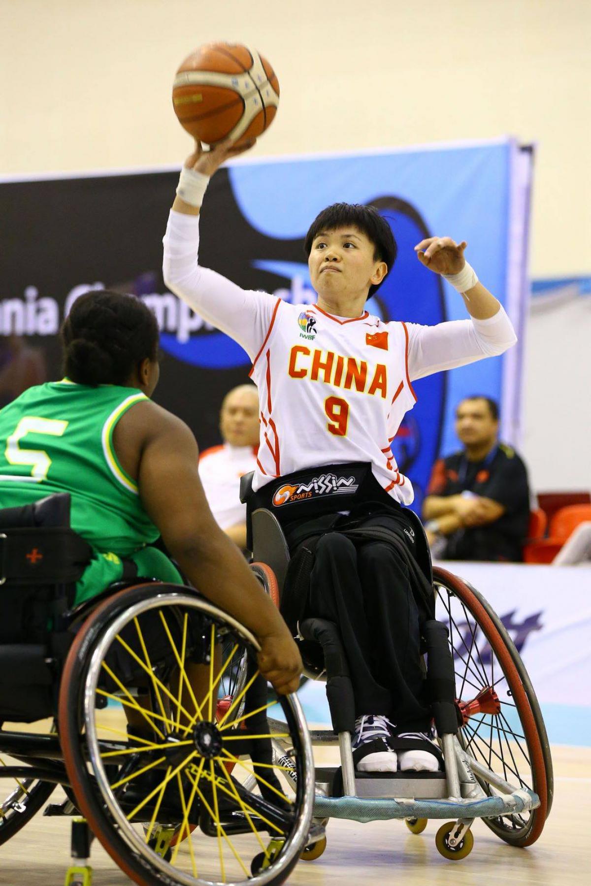 Chinese woman in wheelchair about to shoot basketball