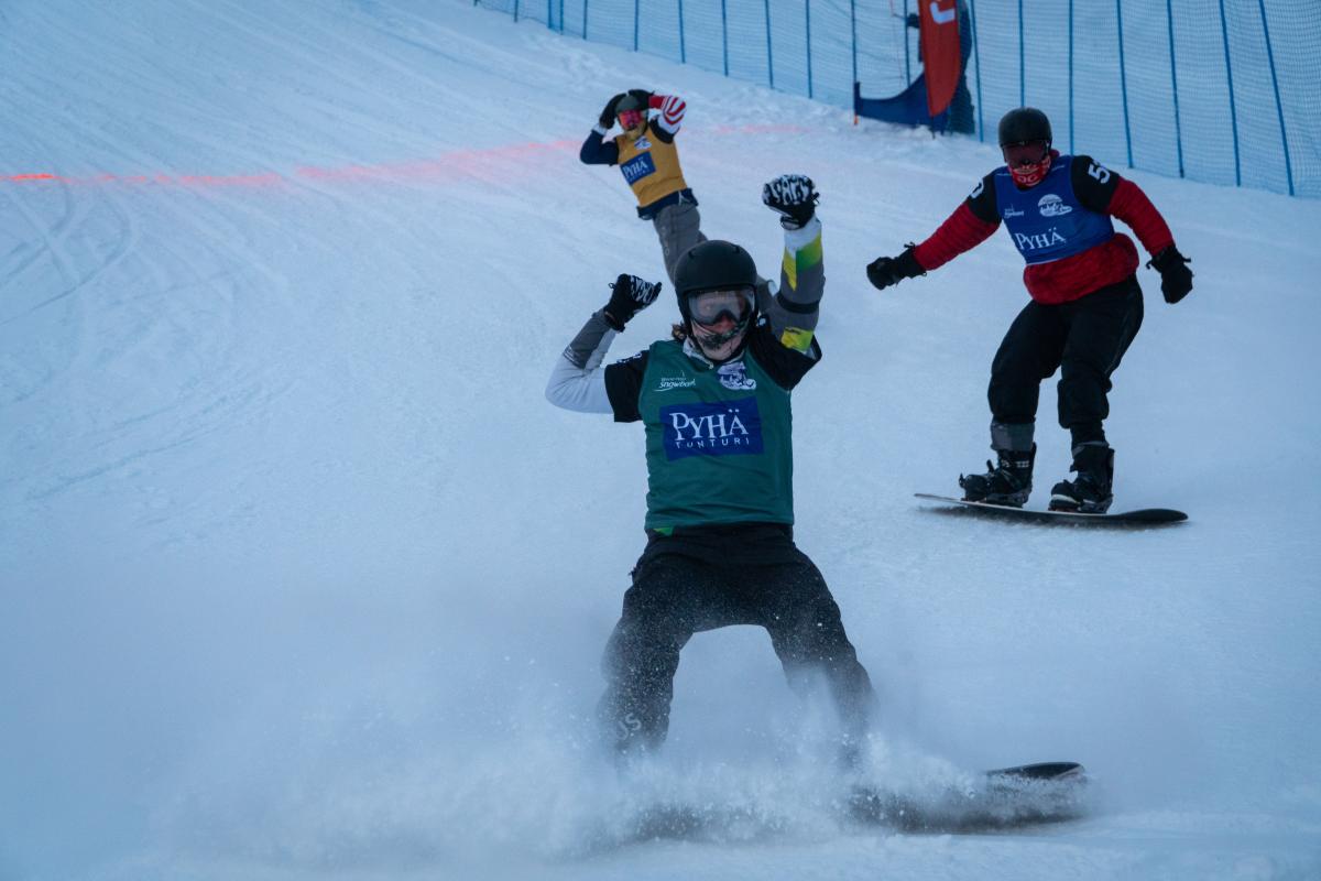 Male snowboarder celebrates after crossing finishline