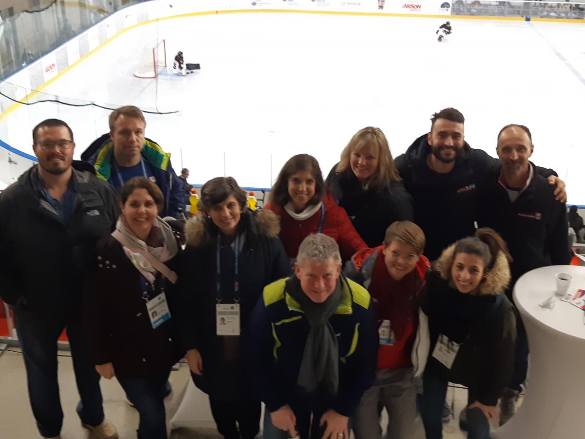 Group photo of meeting members inside an ice arena