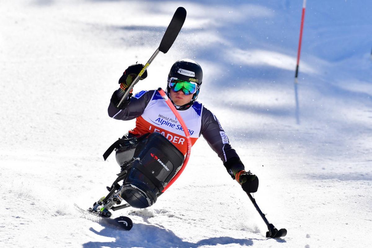 A male sitskier competing in the snow