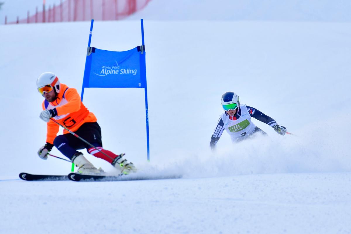 A female Para alpine skier behind her guide