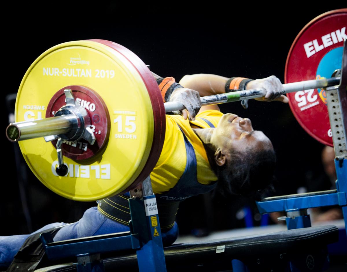 Female powerlifter holds onto the bar preparing for her lift