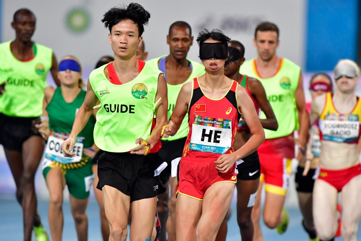 Chinese vision impaired runner with her guide