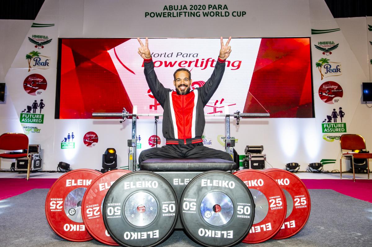 A man on a bench press with six discus in front of the bench