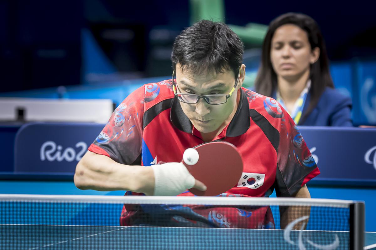 Korean male in wheelchair hits return shot in table tennis