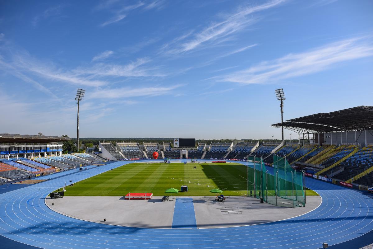 A stadium with a blue athletics track and field 