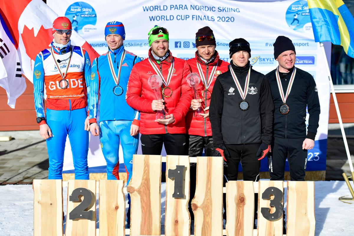 Six men standing on a podium with their medals