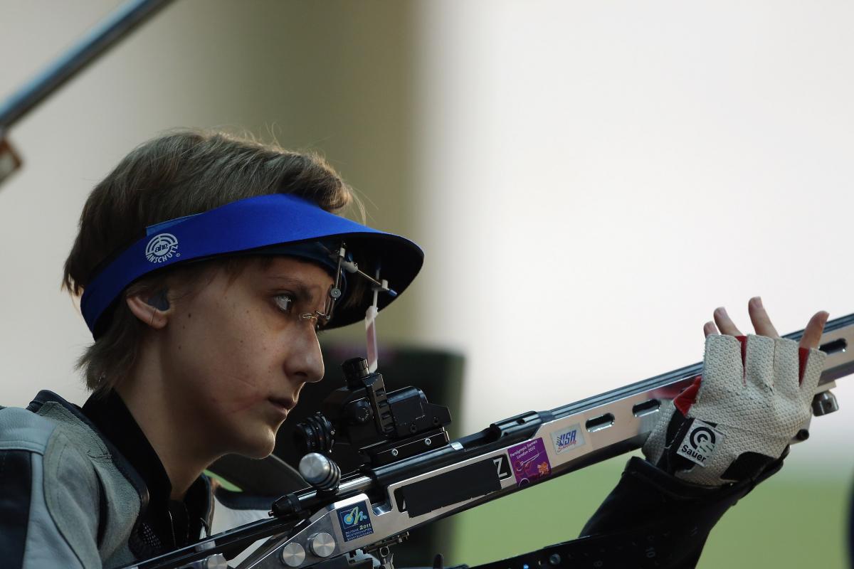 A woman holding a rifle in a shooting Para sport competition
