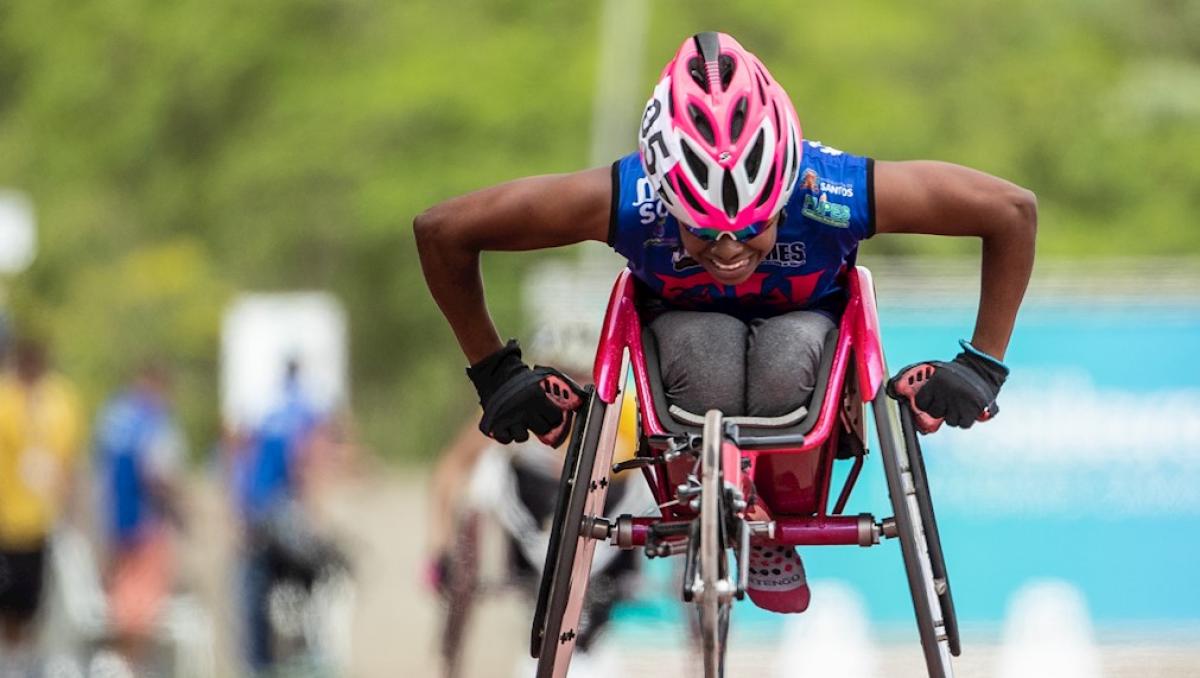 Vanessa Cristina de Souza pushing her wheelchair forward during a competition