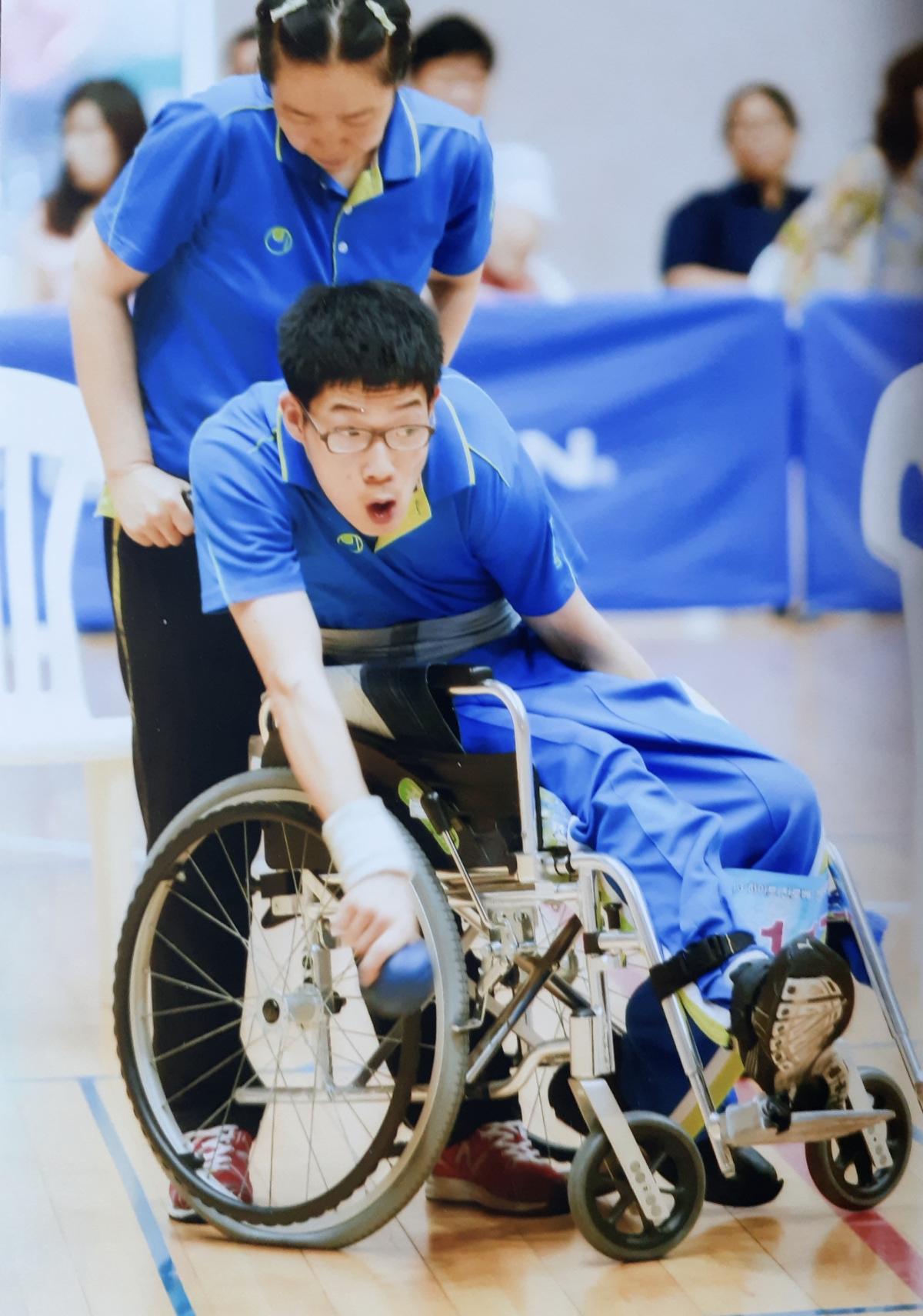 Youngjin Roh throws the jack while his mother holds the wheelchair