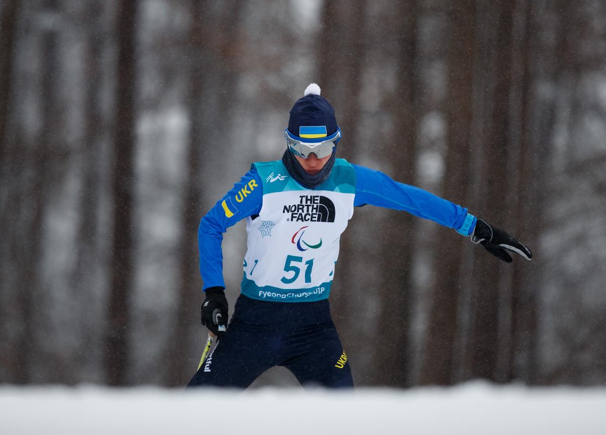 A female standing Para biathlete in the snow