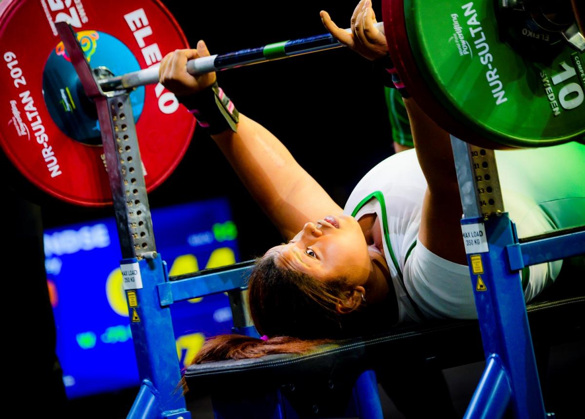 A female Para powerlifter preparing to lift the bar