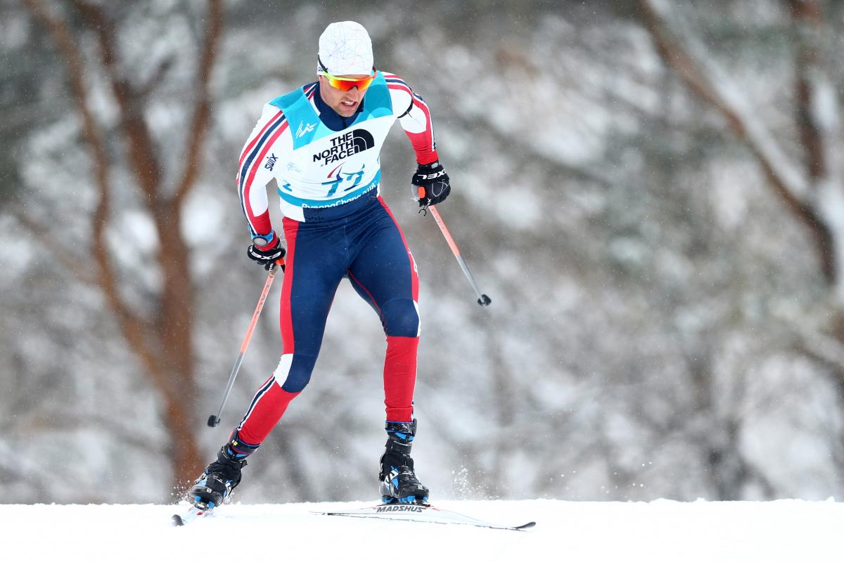 Norwegian male standing skier competes in biathlon