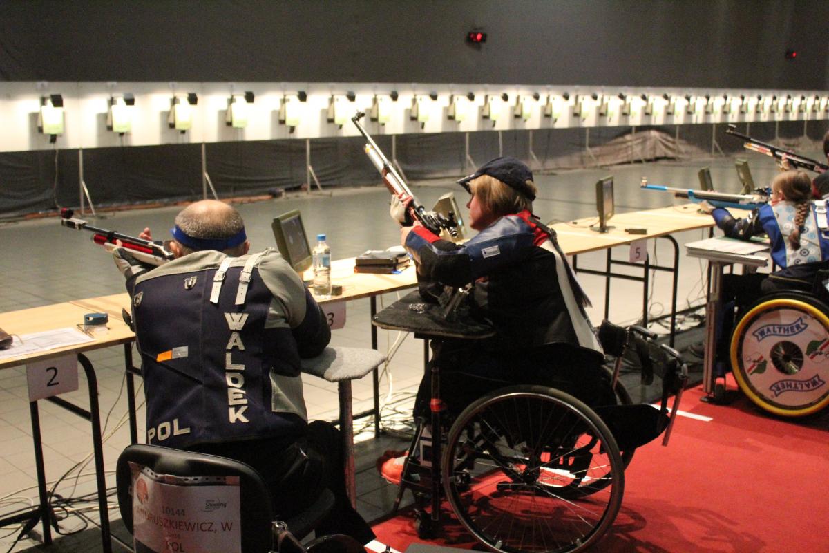 Four people in wheelchairs taking part in a shooting competition