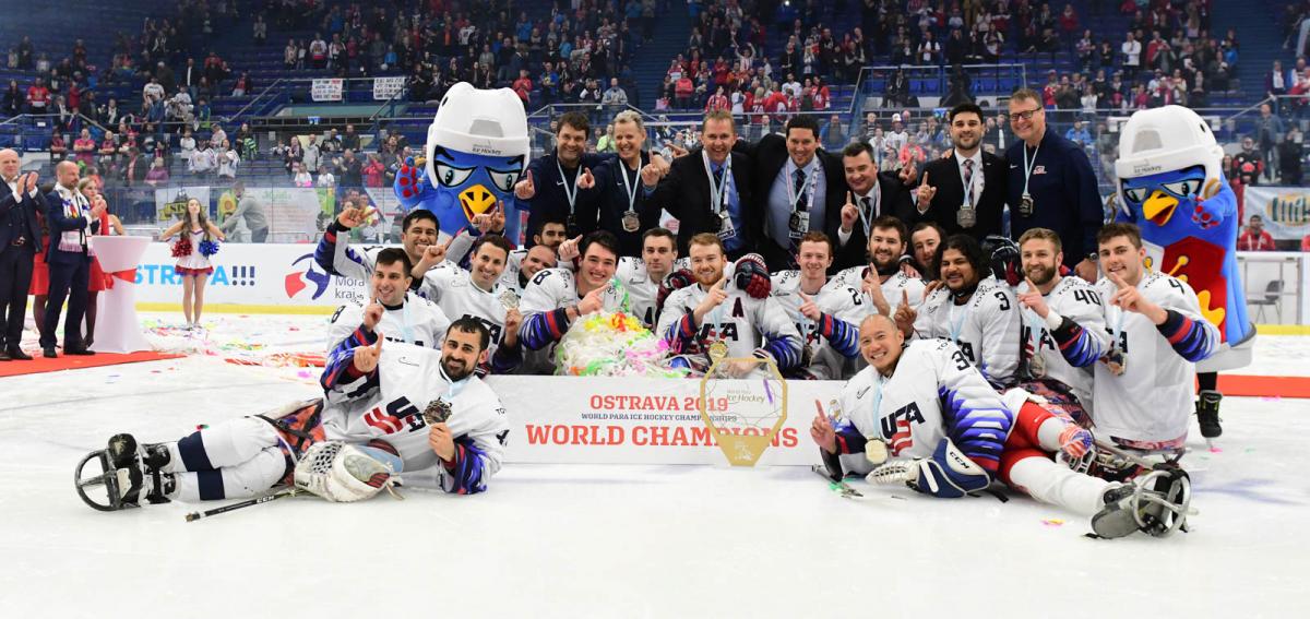 A group of men on an ice rink celebrating with their medals