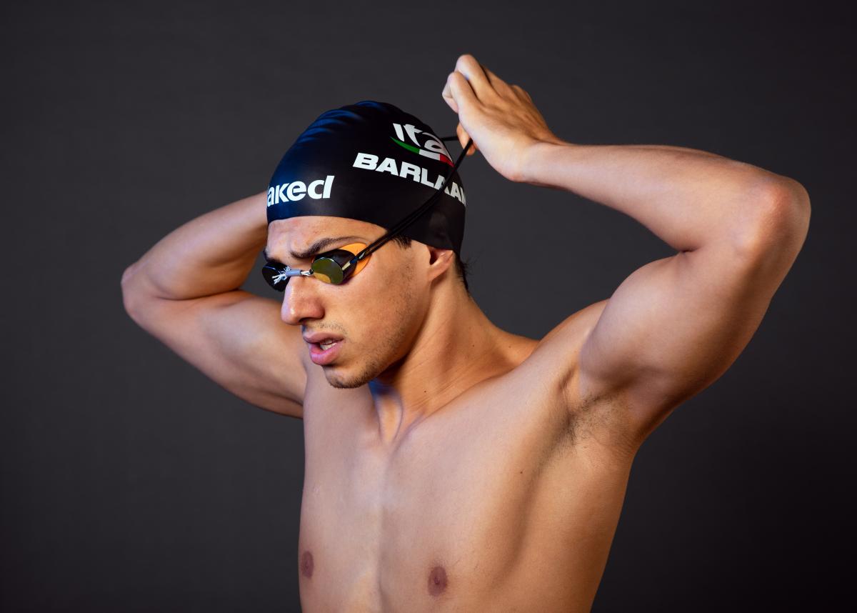 A male swimmer adjusting his swim cap