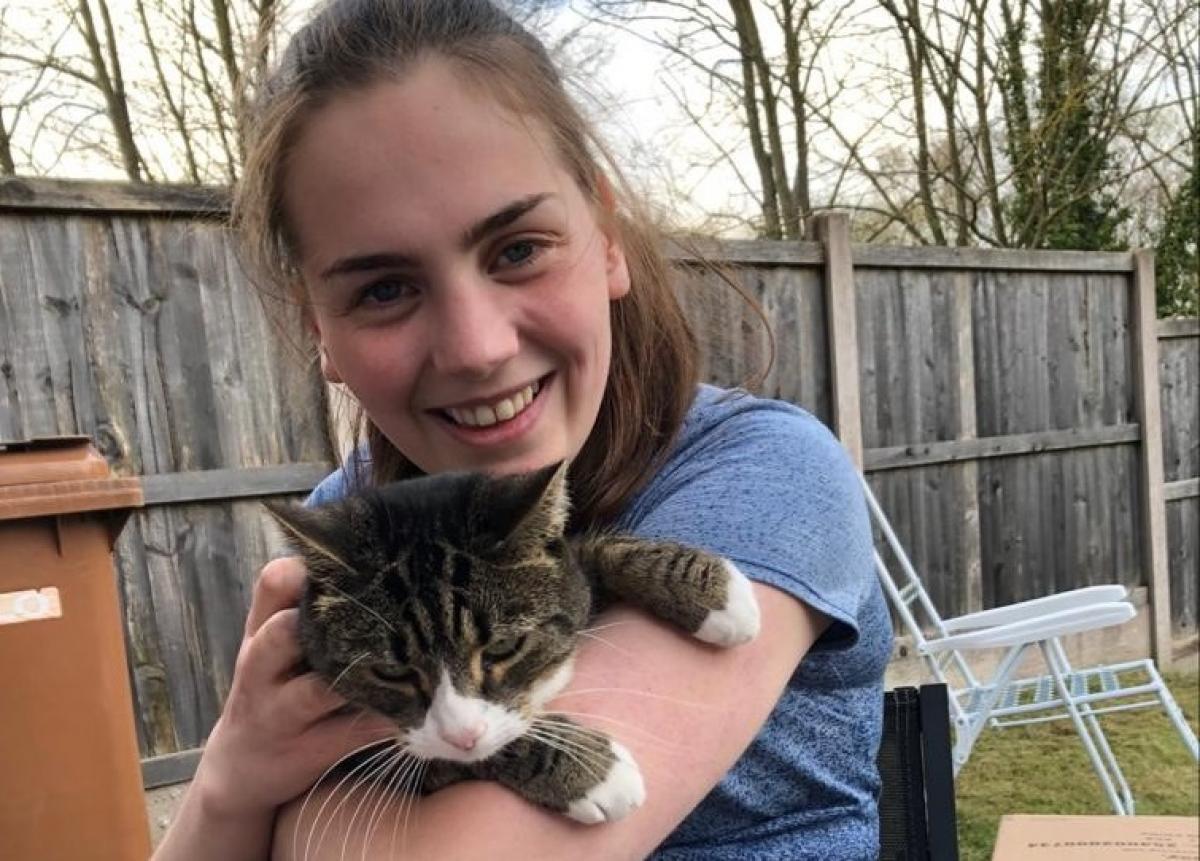 A young woman in a wheelchair holding a cat