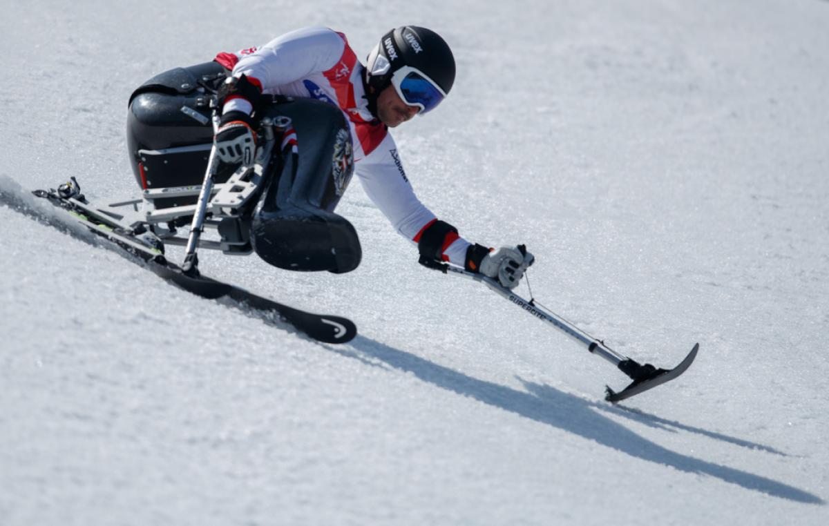 A male sit-skier making a turn in the snow