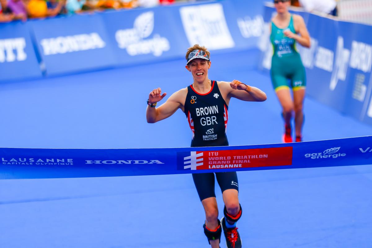 British female Para triathlete celebrates before she crosses the finish line