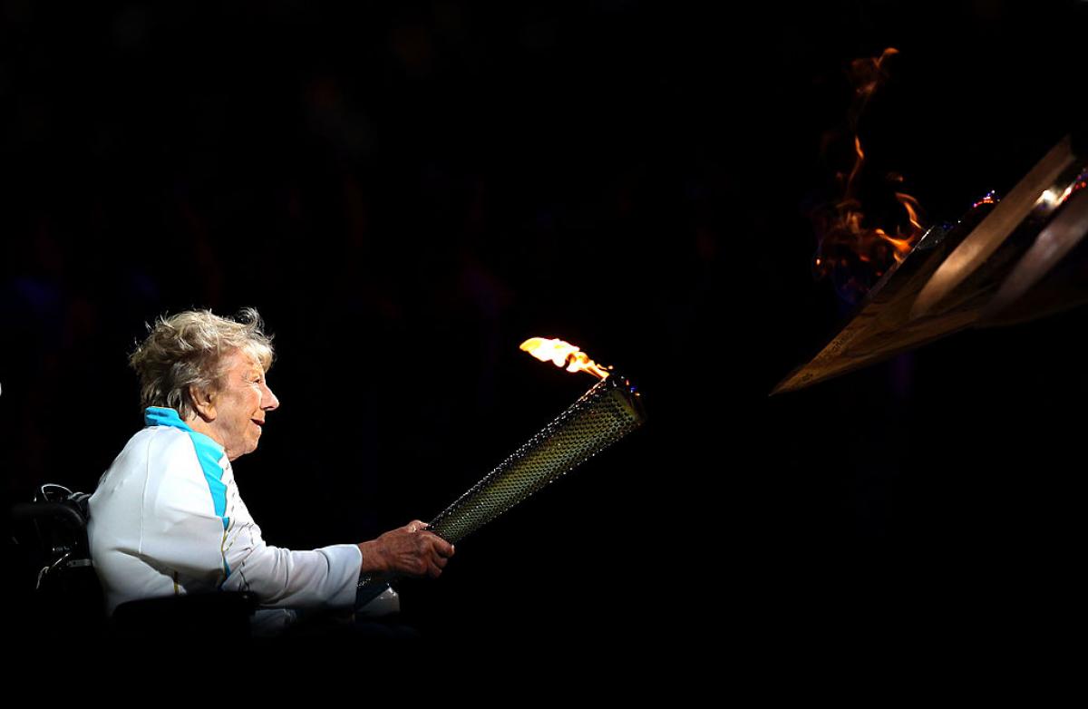 Older female woman in wheelchair lighting cauldron of Paralympic Games